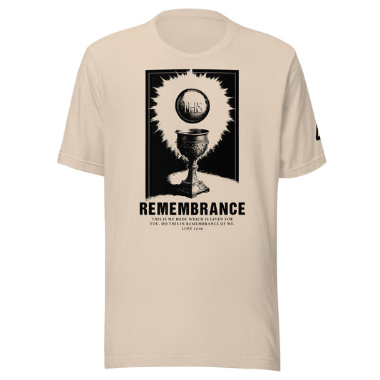 A beige crewneck T-shirt featuring a black graphic print of The Catholic Eucharist with the word 'REMEMBRANCE' and smaller text of the bible verse Luke 22:19. Catholic Clothing.