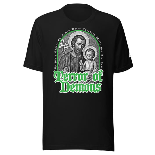 A black short-sleeve T-shirt with a large graphic print on the front. The graphic features a circular religious icon of Saint Joseph and the Child Jesus in grayscale, with the text 'Terror of Demons' in a stylized green font below it. Catholic Clothing.